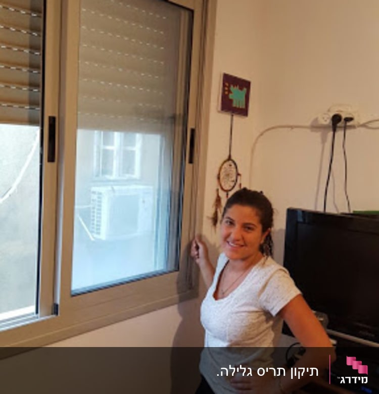 חלון עם תריסים סגורים למחצה בחדר